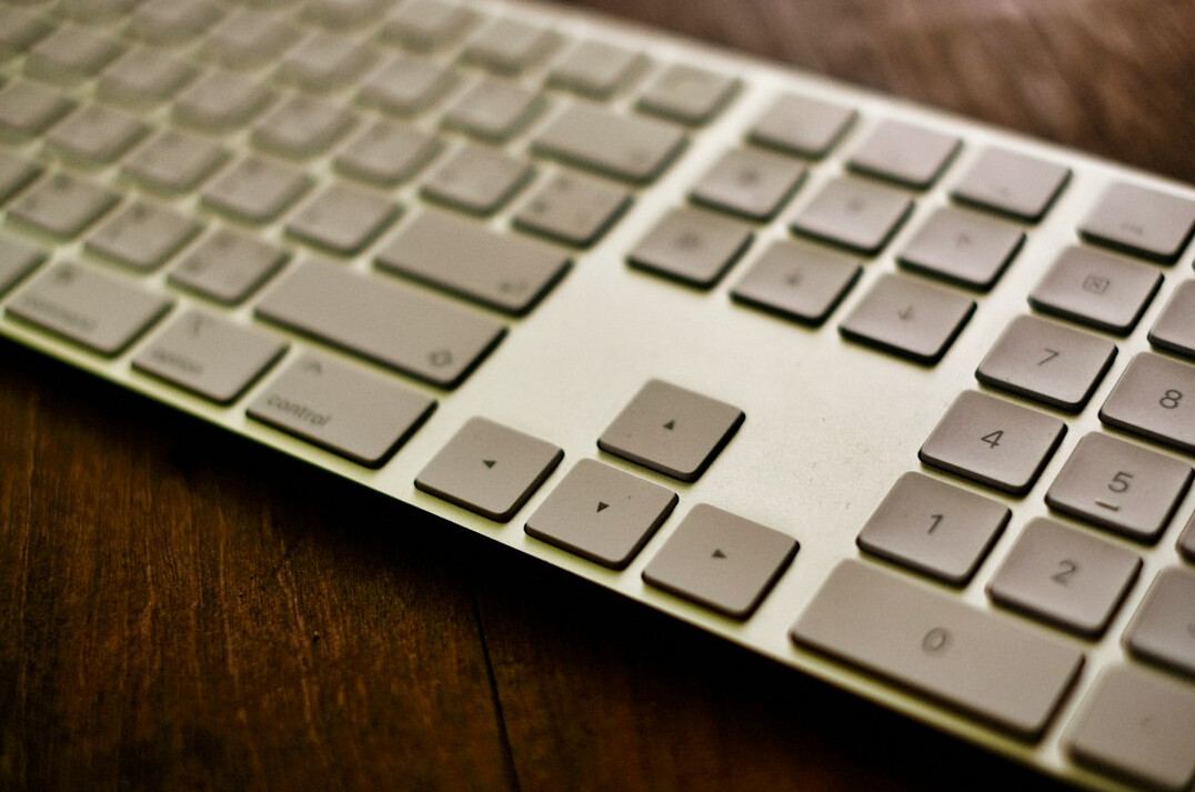Hands typing on a laptop keyboard with chart overlay